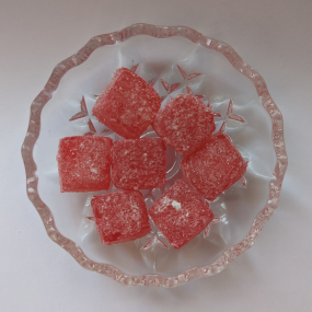 Red kola cube sweets on glass dish