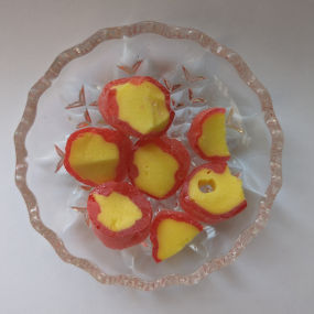 Red and yellow pineapple rock sweets on a glass dish