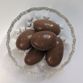 Chocolate covered Brazil nuts on glass dish