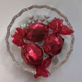 Wrapped raspoberry coconut ruffles sweets on glass dish