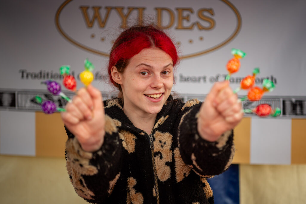 A woman holding lollipops at a market stall